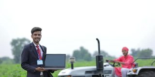 年轻的印度农学家或银行家与农民在农业领域展示笔记本电脑屏幕