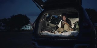 年轻女子晚上在车里露营