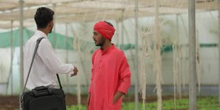 年轻的印度农学家在温室与农民讨论