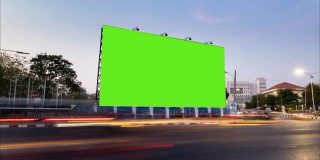 时间流逝的交通在晚上与空白的广告广告牌绿色屏幕。