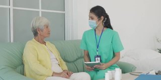 亚洲专业护士或家庭健康助手，在家里给老年妇女服药。老年患者居家保健与医疗理念。