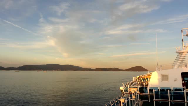 假期邮轮在日落天空中与岛屿在日本海洋中旅行的时间流逝。