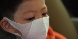 亚洲儿童戴上卫生口罩，保护自己免受冠状病毒大流行的影响