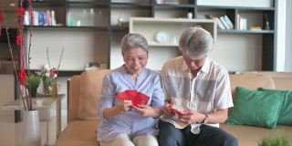 过年老两口祖父母在客厅为家人准备红包红包