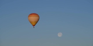 在卡帕多西亚的山丘间，热气球在满月下飞行