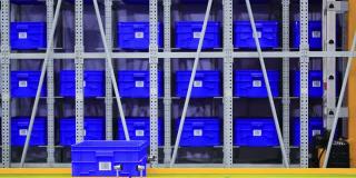 巨大的蓝色塑料集装箱堆放在配送仓库的板条箱里。
