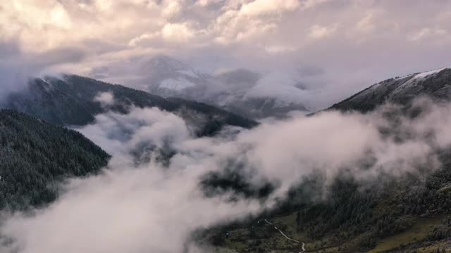 日落时分，新下了雪的群山中弥漫着雾气