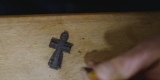 木雕师用刀切割正统的乌木十字架。工匠在木十字架上雕刻。