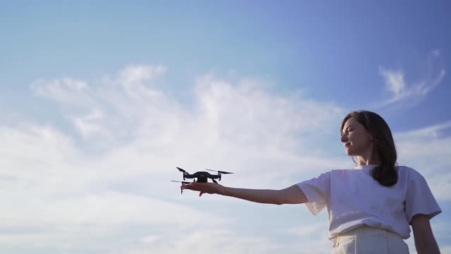 女子将无人机从手掌中发射出来。在天空中起飞四轴飞行器，变换焦点