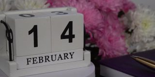 桌面日历与2月14日的日期和一束美丽的鲜花。