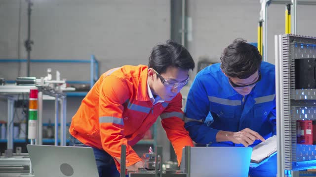 两位工程师检查和讨论零件制造的机器人工厂设计师在车间测试机器人原型。科学概念