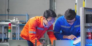 两位工程师检查和讨论零件制造的机器人工厂设计师在车间测试机器人原型。科学概念