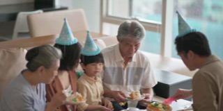 亚洲华人多代家庭庆祝生日，用菜刀切生日蛋糕