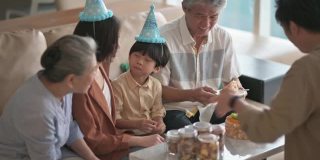 亚洲华人多代家庭庆祝生日，用菜刀切生日蛋糕
