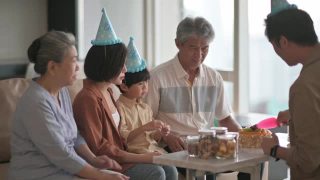 亚洲华人多代家庭庆祝生日，用菜刀切生日蛋糕视频素材模板下载