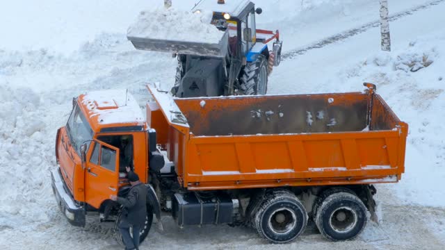 公用事业服务。一场大雪过后，要把道路上的积雪清理干净。拖拉机和翻斗车。
