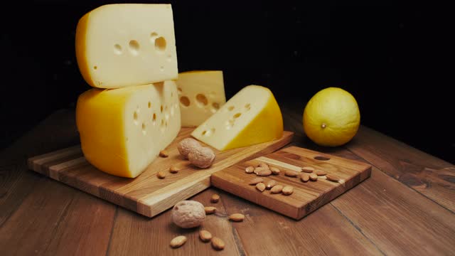 中等硬度的奶酪头，伊达豪达干酪放在木板上，加坚果和蜂蜜。幻灯片拍摄