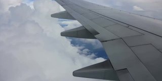 飞机的机翼在多云的天空中飞行