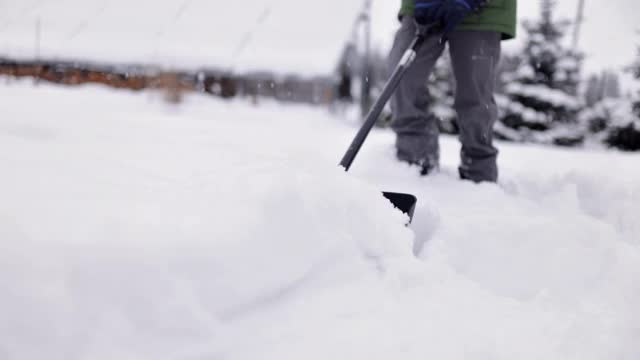 一个十几岁的男孩在帮忙清除后院的积雪