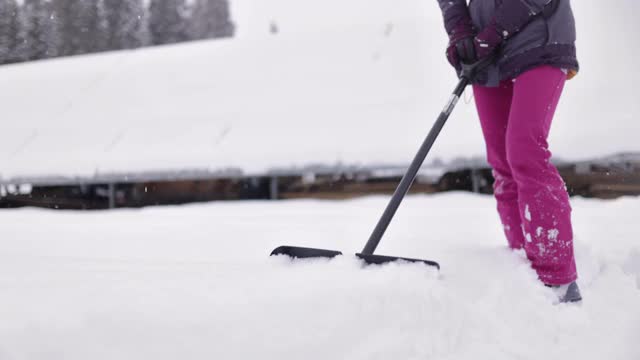 十几岁的女孩帮助清除后院的雪