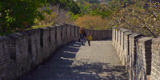 斯坦尼康镜头拍摄了一个年轻的女人和她的小儿子走上中国长城的楼梯