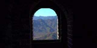 斯坦尼康镜头拍摄的中国长城，在山的一侧上升在一个开始下降。摄像头通过瞭望塔的通道，显示了从墙上的窗户看到的景色