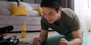 亚洲男子教或指导他的在线学生在家锻炼。视频博主为他的直播或社交媒体上的视频制作内容。