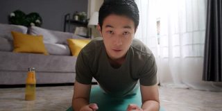 亚洲男子教或指导他的在线学生在家锻炼。视频博主为他的直播或社交媒体上的视频制作内容。