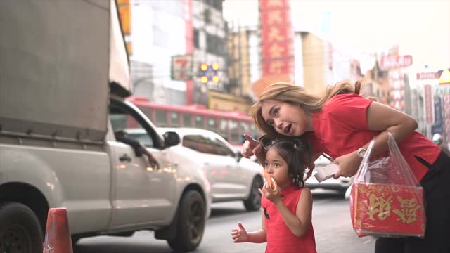 亚洲华人家庭在街头中国市场购物庆祝中国新年。