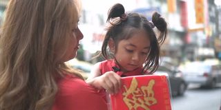 亚洲华人家庭在街头中国市场购物庆祝中国新年。