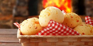 自制的奶酪面包，巴西的传统小吃，放在篮子里，离开烤箱后放在乡村厨房的桌子上