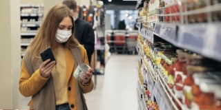超市里，一名妇女戴着医用口罩扫描商品上的条形码