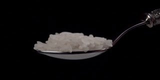 一勺生米。缓慢下落的颗粒