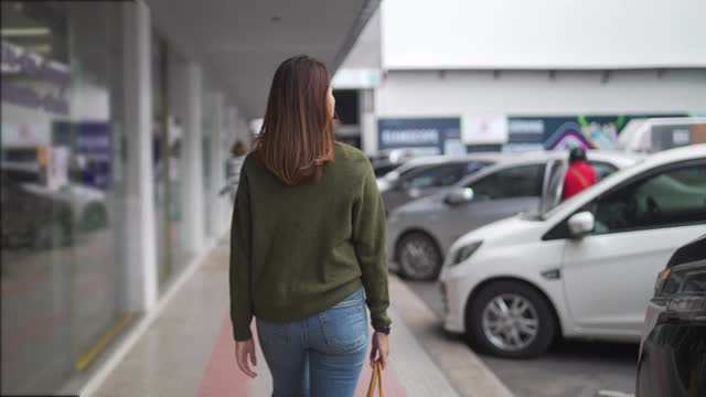 快乐的亚洲女人走在城市里