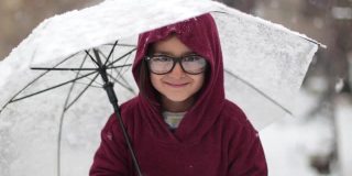 小女孩在雪下打着伞