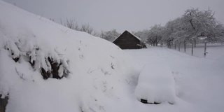 乡野的谷仓和厕所下着雪，冬村下着雪