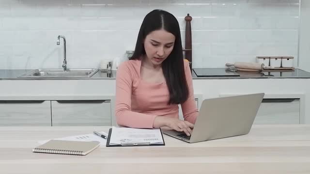 一个美丽的亚洲女人在笔记本电脑上工作认真的在家工作是新的常态