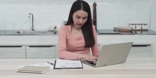 一个美丽的亚洲女人在笔记本电脑上工作认真的在家工作是新的常态