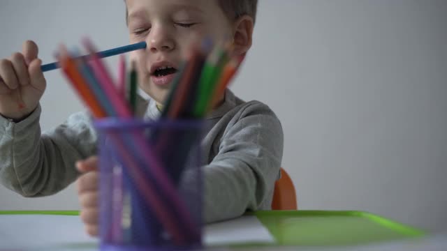 童年，艺术，教育，创意概念-真实的学前儿童未成年聪明的创意天才男孩2-4岁用彩色铅笔画画家庭的春天夏天，家里的彩虹