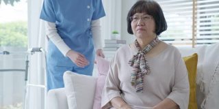 年轻的亚洲妇女或护士在家照顾手在老祖母的肩膀给予支持，同情老年妇女或老年人在辅助生活家庭照顾精神健康疾病救济的概念。