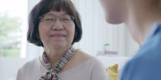 后视图年轻的亚洲女性或护士的家庭护理与年长的祖母给予支持，同情老人的女士或老年人在辅助生活的家庭护理精神健康救济的概念。
