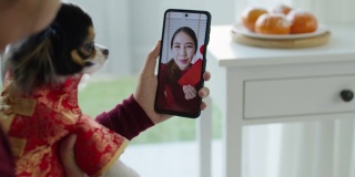 观点自拍视频通话的美丽迷人的年轻亚洲女士在红色春节庆祝服装快乐的微笑交谈和看相机手机祝农历节日。