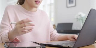年轻有吸引力的商业亚洲女人谈论销售报告在视频电话会议上笔记本电脑在线会议在家工作，远程工作和社会隔离的概念。