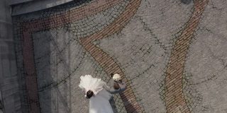 可爱的白种新人新郎新娘在公园里牵着手，新婚夫妇一家人