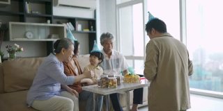 亚洲华人父亲在儿子的生日庆典上给他的父母送蛋糕