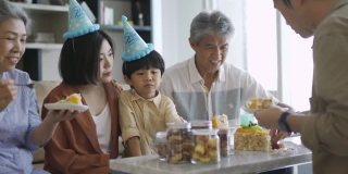 亚裔华人父亲在儿子的生日庆典上给儿子送蛋糕