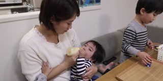 年轻的母亲在家里给她的男婴喂奶