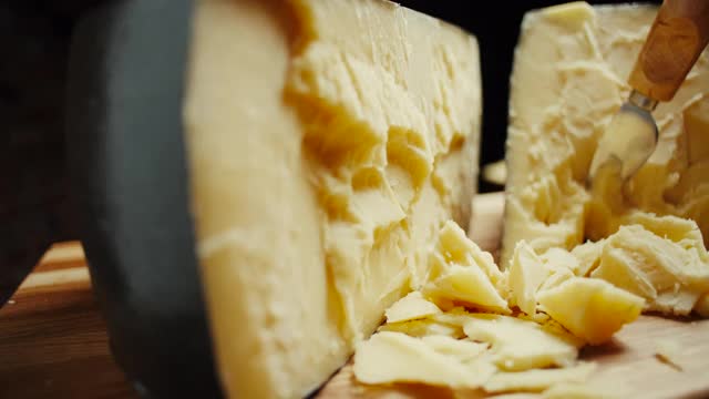 中等硬度的帕尔玛干酪头放在木板上，旋转拍摄