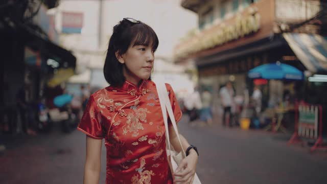 亚洲女性穿旗袍购物。
