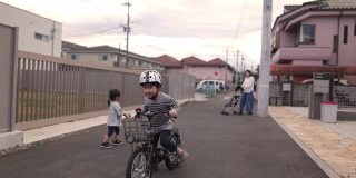 小男孩在街上练习骑自行车